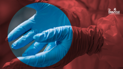 Healthcare worker wearing blue nitrile disposable gloves and protective clothing, with the guide title Choosing the Right Disposable Glove